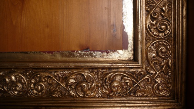 A gold frame with some type of ornate design on it