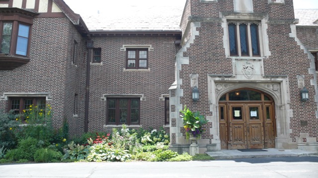 A brick building with flowers in front of it.