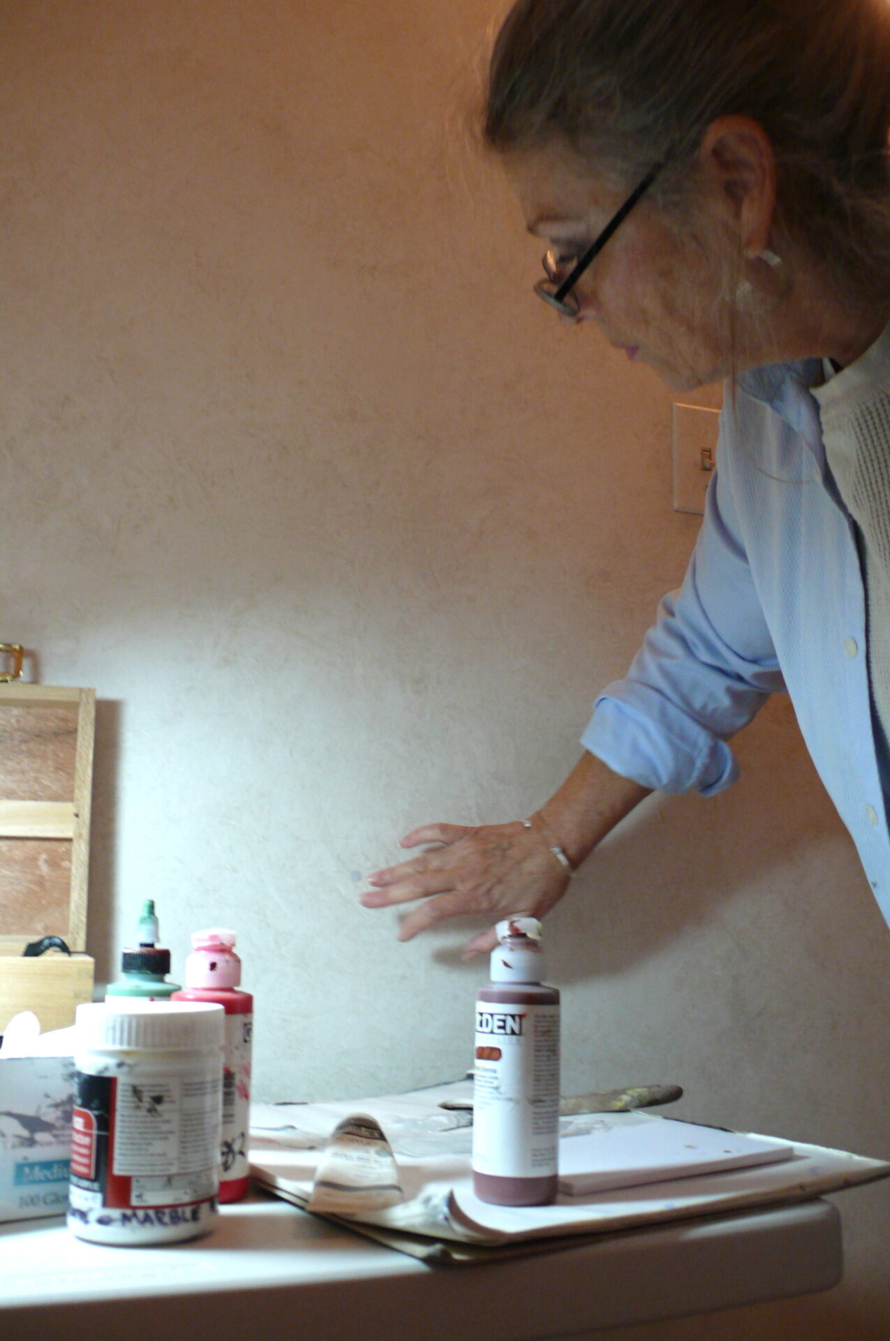 A man standing in front of a table with two bottles.