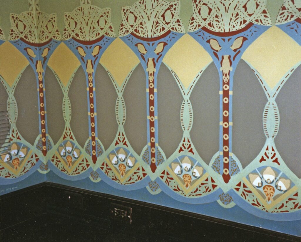 A wall with a painting of an ornate design.