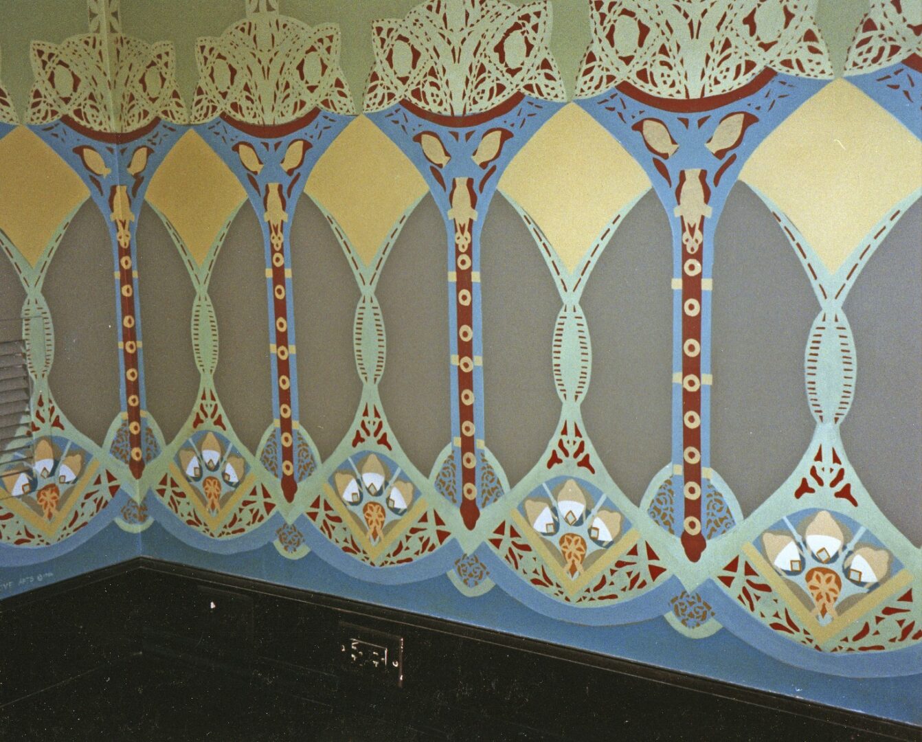 A wall with a painting of an ornate design.